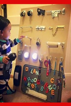 a young boy standing in front of a bulletin board with magnets and lights on it