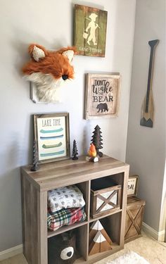 a room with a shelf, stuffed animal head and pictures on the wall above it