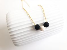 "Welcome to our shop,  This necklace has 2x 8mm black lava bead and 1x8mm white lava bead on a 18K gold plated brass chain with lobster clasp closure. The lava necklace comes in a cardboard gift box. Did you know? - Lava Stone is a grounding stone that strengthens one's connection to Mother Earth. It gives us strength and courage, allowing us stability through times of change. It provides guidance and understanding in situations where we may need to \"bounce back\". A calming stone, it is very useful in dissipating anger. As an added bonus, rub your favorite essential oil on to the lava bead. The essential oils will absorb quickly into the lava bead. Enjoy a subtle aromatic experience for up to a few days! Re-apply oils on to the lava bead as desired. Please choose your prefered chain leng Aromatherapy Jewelry, Cardboard Gift Boxes, Calming Stones, Lava Bead, Lava Stone, Minimalist Necklace, Brass Chain, Crystal Items, Mother Earth