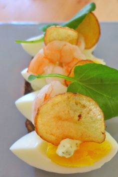 some kind of appetizer that is sitting on a plate with green leafy garnish