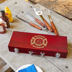 a wooden box sitting on top of a sidewalk next to bottles and utensils