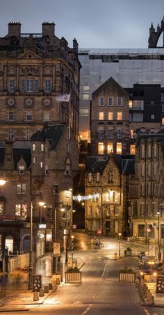 a city street at night with lots of tall buildings