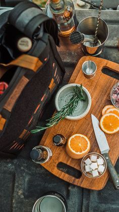 a wooden cutting board topped with sliced oranges and ice cubes on top of a table