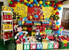 a birthday party with mickey mouse decorations and balloons on the wall, including an assortment of toys