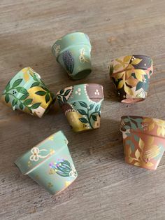 five different colored flowered paper cups sitting on a table