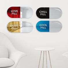 there are four different colored pill shaped magnets on the wall next to a white chair