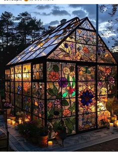 a house made out of stained glass with candles in the front and flowers on the side