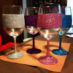 three wine glasses with different colored glitters on them