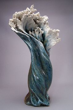 a blue vase with white flowers in it on a gray background and grey back ground