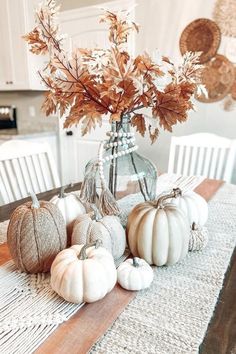 some white pumpkins sitting on top of a wooden table