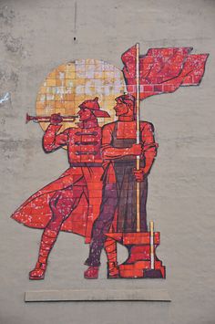 a painting on the side of a building depicting two men holding flags and standing next to each other