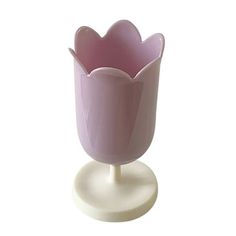 a pink vase sitting on top of a white stand