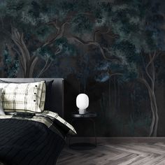 a bedroom scene with focus on the bed and wallpaper that has trees painted on it