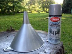 a can of krylon rust next to a metal cone on a tree stump