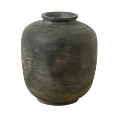 a large black vase sitting on top of a white surface