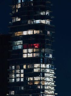 a very tall building with lots of windows lit up in the dark night time sky