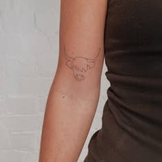 a woman's arm with a tattoo of a bull head on the left side of her arm