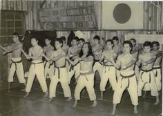 an old black and white photo of some people in karate attire with their hands on their hipss