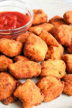 some fried food on a white plate with ketchup