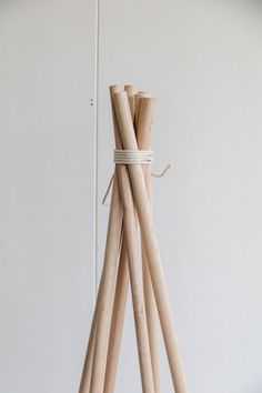 a group of wooden sticks tied up to each other on a white surface with a wall in the background