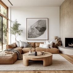 a living room with a couch, coffee table and fire place in front of a large window