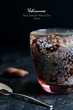 a glass filled with food next to a spoon