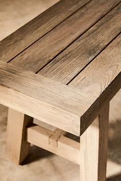 a wooden bench sitting on top of a cement floor