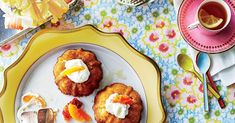 three pastries on a yellow plate next to a cup of tea and silverware