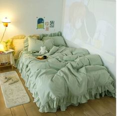 an unmade bed sitting on top of a hard wood floor next to a lamp