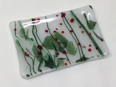 a white plate with green and red designs on it