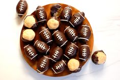 chocolate covered candies with footballs on them in a wooden bowl next to cookies