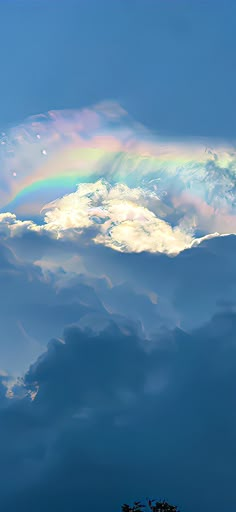 a rainbow in the sky above some clouds