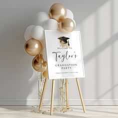 a graduation party sign with gold and white balloons