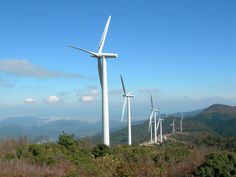 several wind turbines on top of a hill