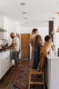 a group of people standing around a kitchen