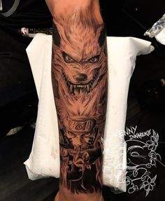 a man's leg with tattoos on it and an image of a wolf in the background