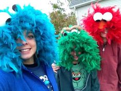 three people in costumes posing for a photo with their faces painted like sesame street characters