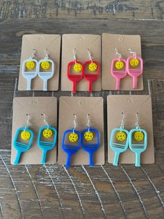 six pairs of earrings with smiley faces on them