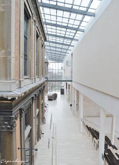 an empty building with lots of windows and benches