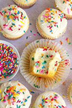 cupcakes with white frosting and colorful sprinkles