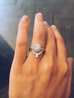 a woman's hand with a ring on it and a diamond in the middle