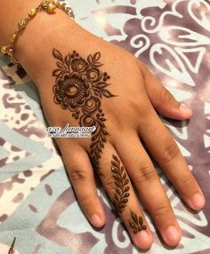 a woman's hand with henna tattoos on it