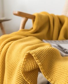 a yellow blanket sitting on top of a bed