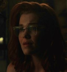 a woman wearing glasses in the dark