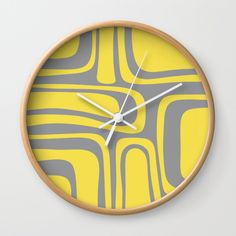 a yellow and grey wall clock with an abstract design