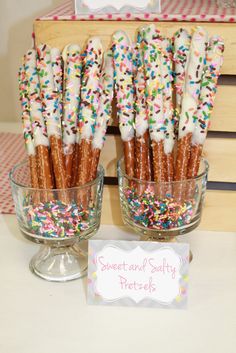 there are many sprinkles on the sticks in this glass bowl and sign