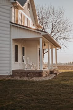 a white house sitting on top of a lush green field