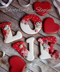 decorated cookies in the shape of numbers and hearts on a wooden table with ribbons around them