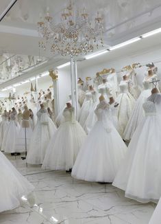 a room filled with lots of white dresses