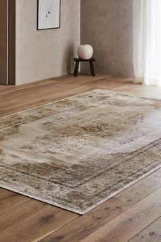 a large area rug in the middle of a room with wooden floors and white walls